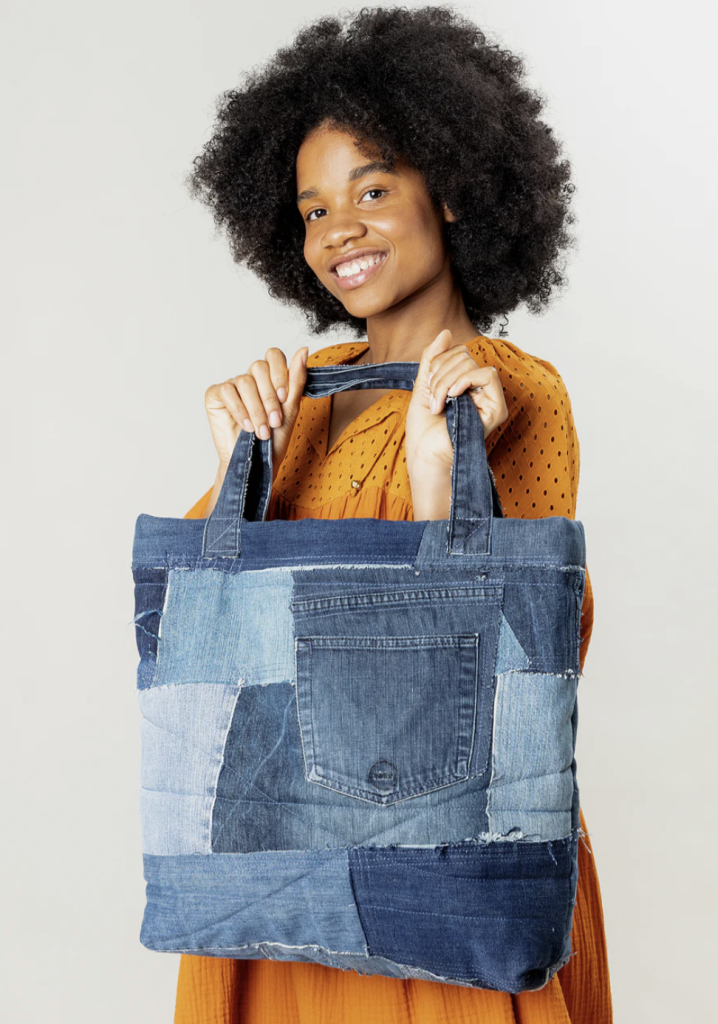 A girl holding an upcycled patched bag.